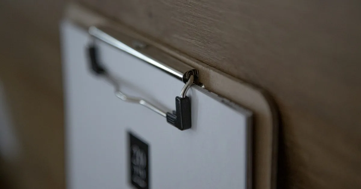 A clipboard holding a printed month calendar