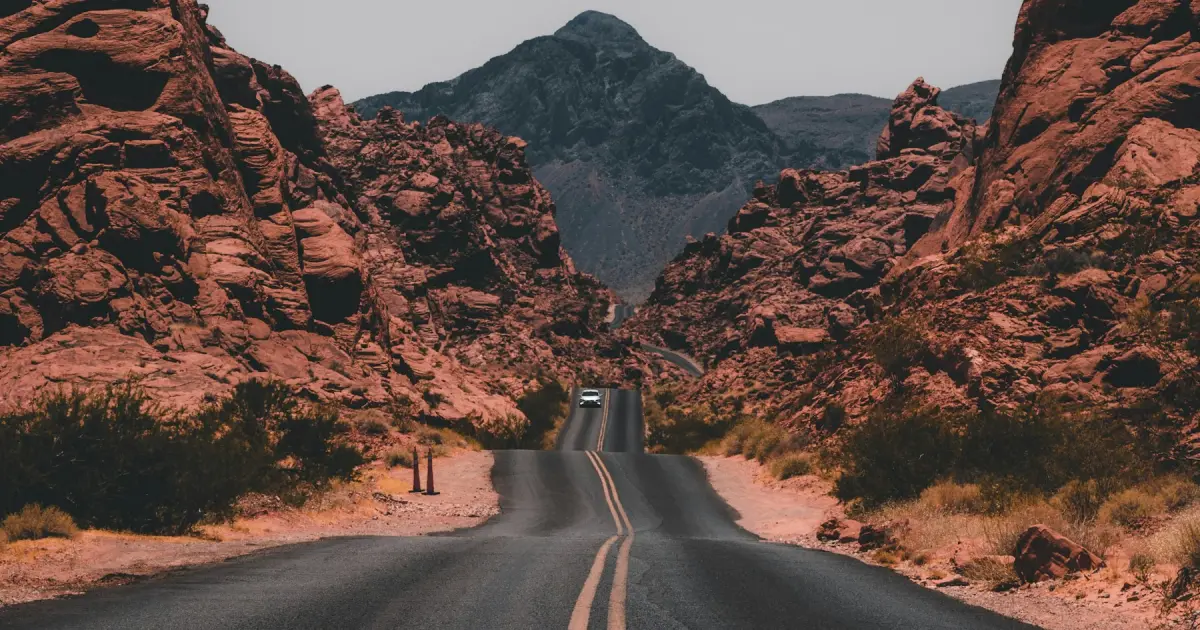 A two-lane road curving through red rock desert