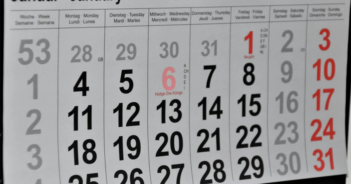 A wall calendar hanging above a desk
