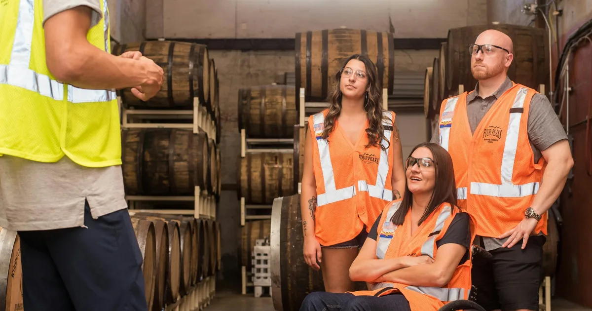 Three workers in orange high-visibility vests standing together