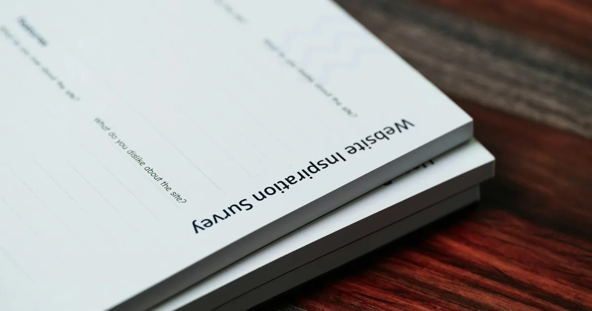 A stack of printed papers resting on a wooden table