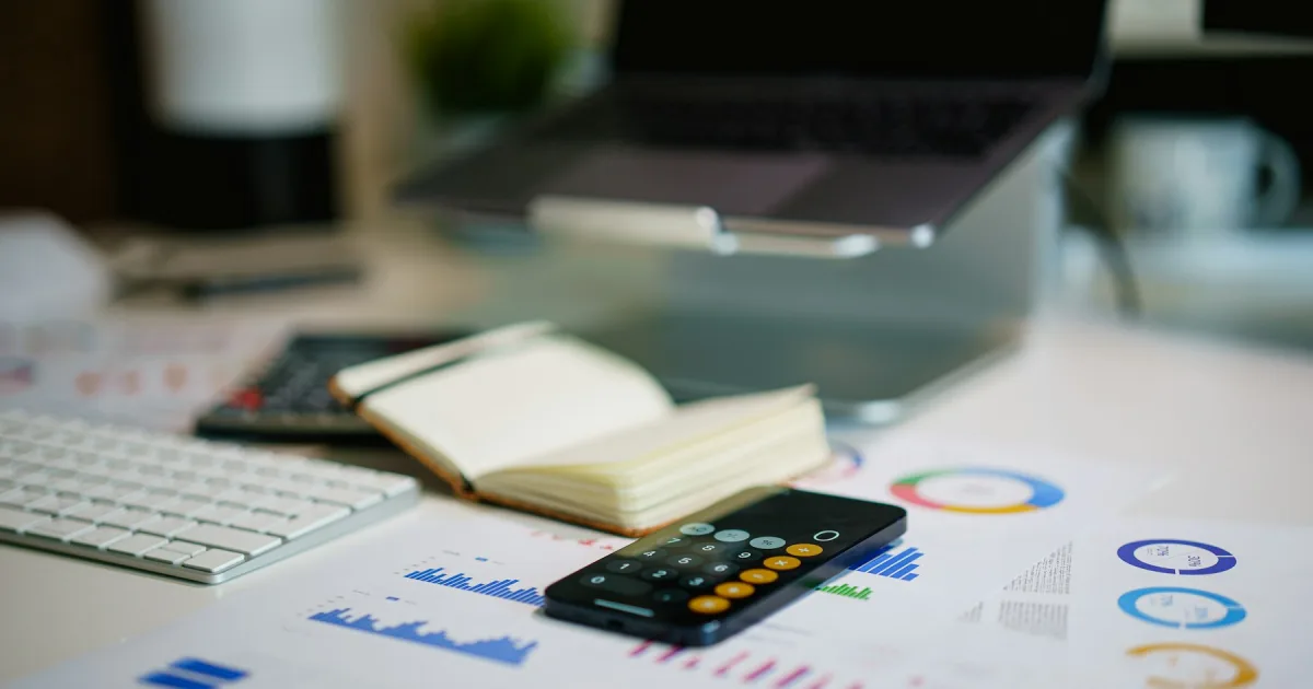 A financial report with cost calculations spread on a desk